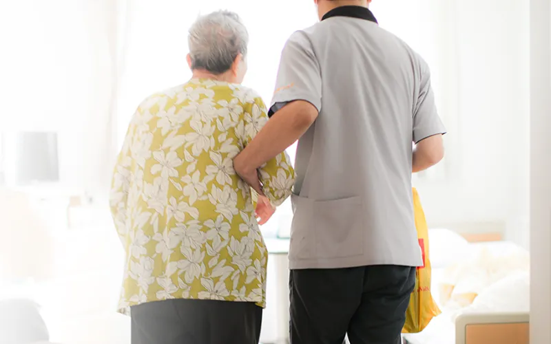 利用者さまの手を引く介護職員