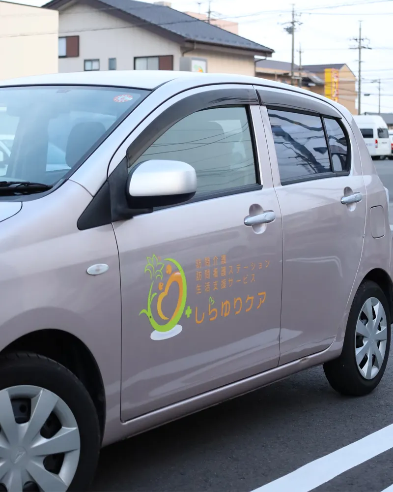 しらゆりケアの施設ロゴが入った車両